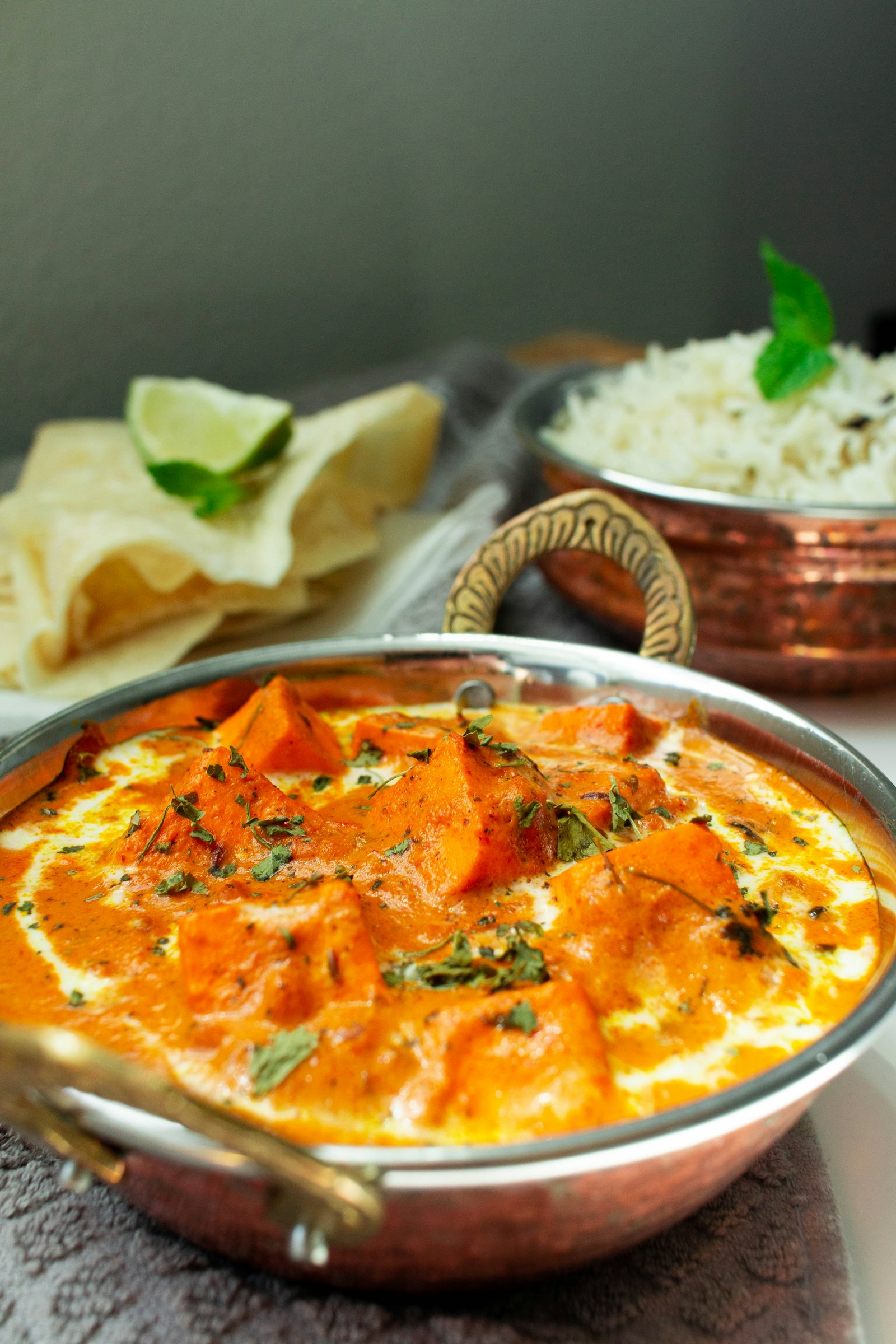 Paneer in Tomaten-Sahne-Curry mit Brot und Reis